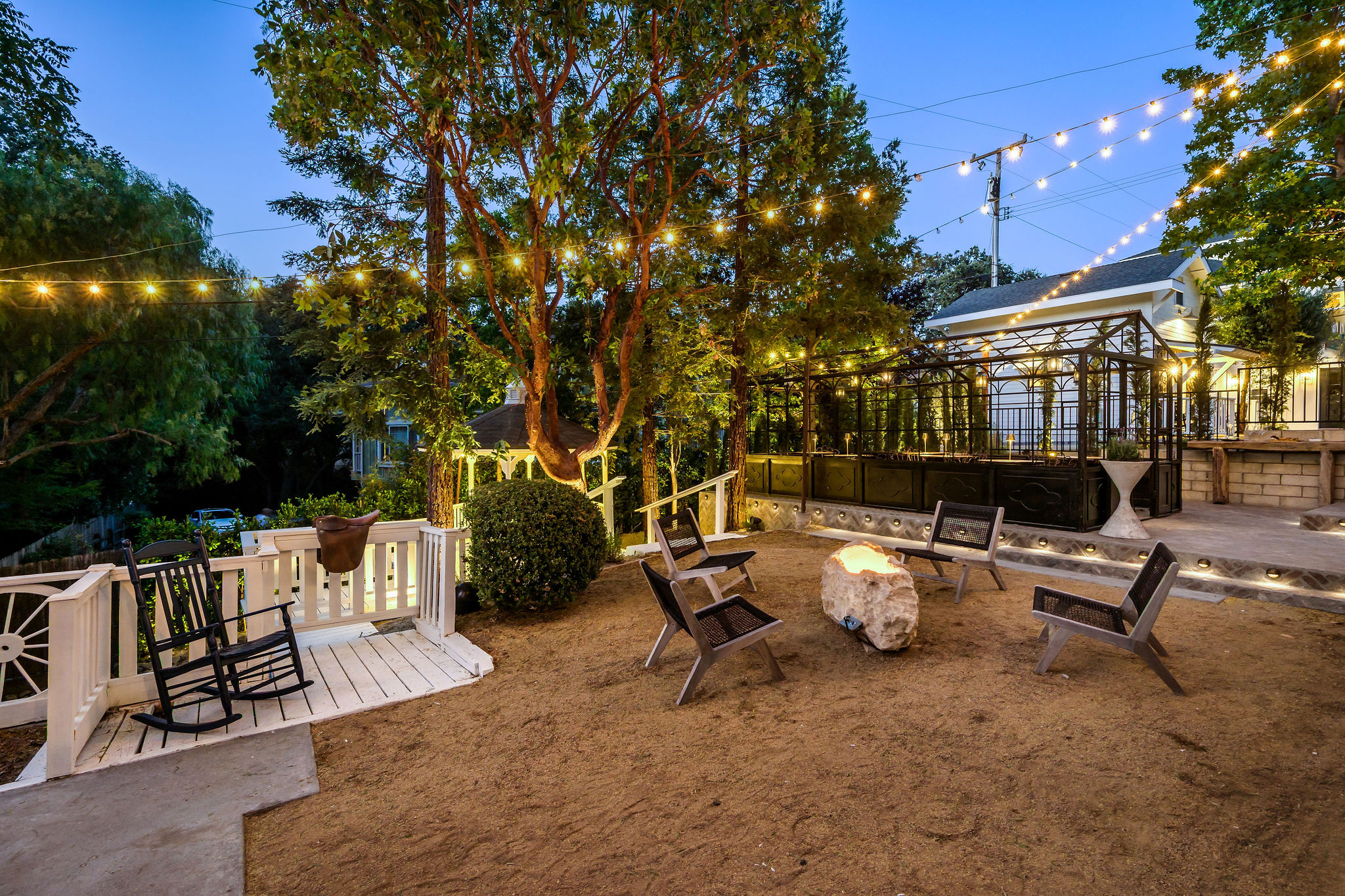 The fire pit lounge under string lights at dusk