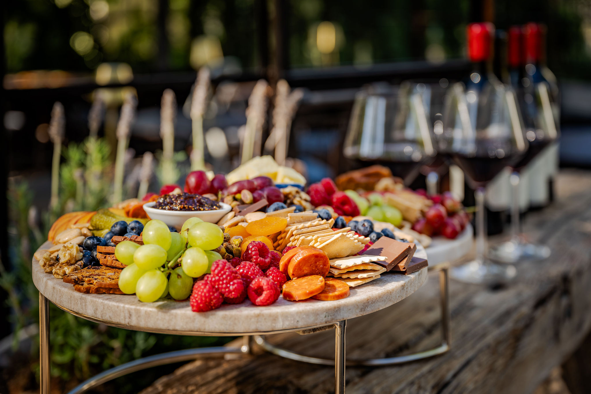 A charcuterie board with fruit, cheese, and glasses of local red wine at The Polo House Aperitif