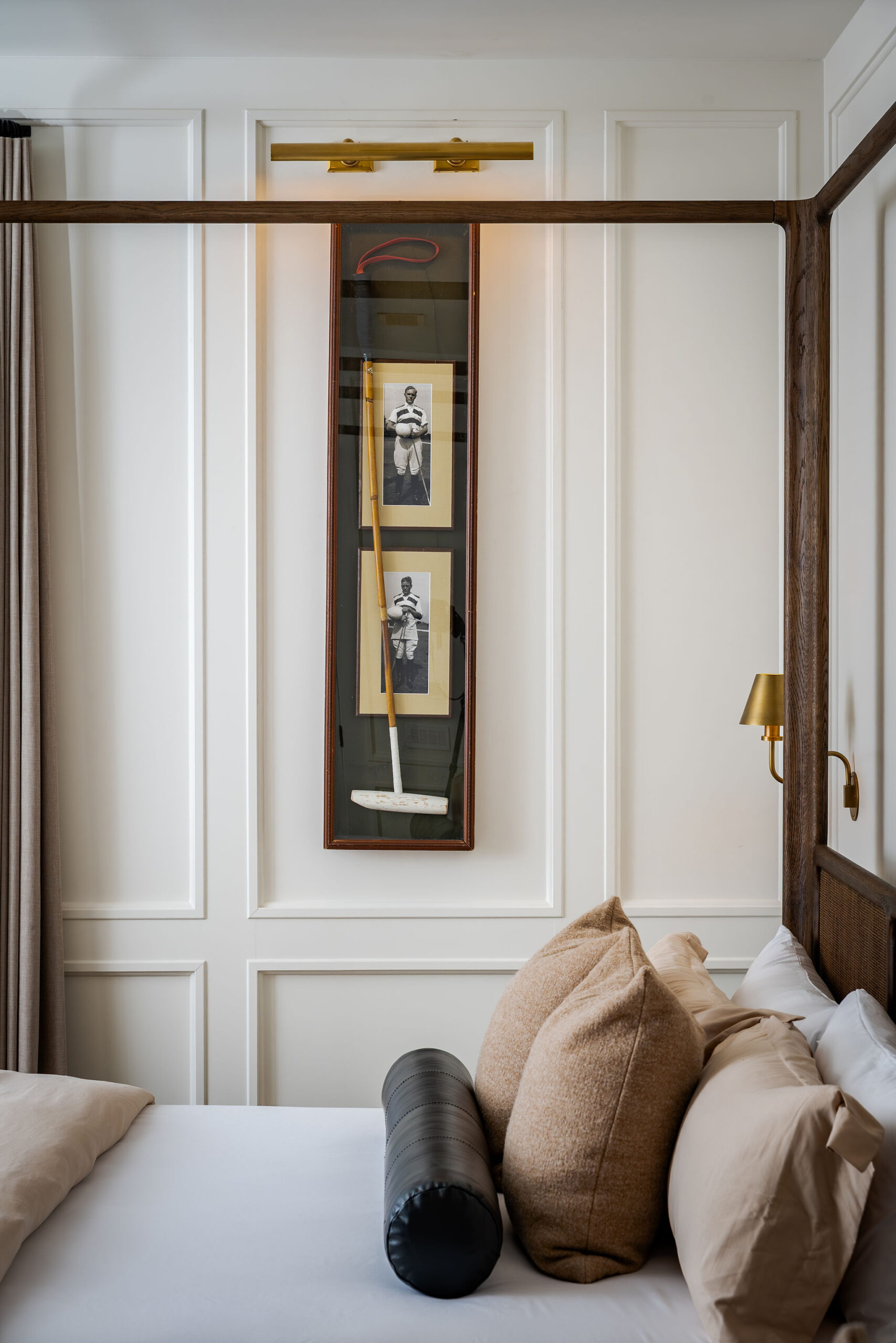 A four-poster guest room with framed polo memorabilia at The Polo House